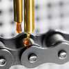 Automatic lubricator applying ROCOL high temperature chain oil to a roller chain