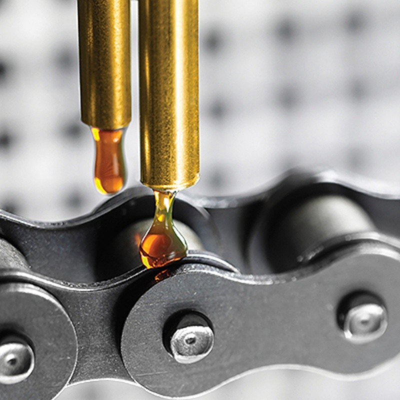 Automatic lubricator applying ROCOL high temperature chain oil to a roller chain